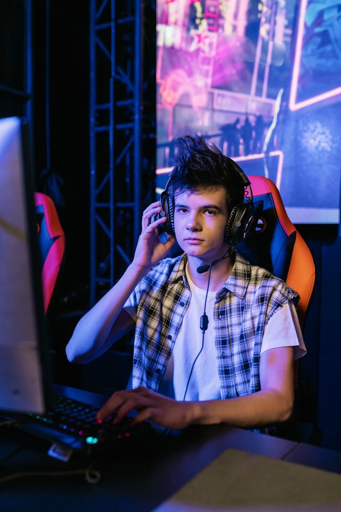 Teen gamer wearing headphones focused on an intense multiplayer game session indoors.